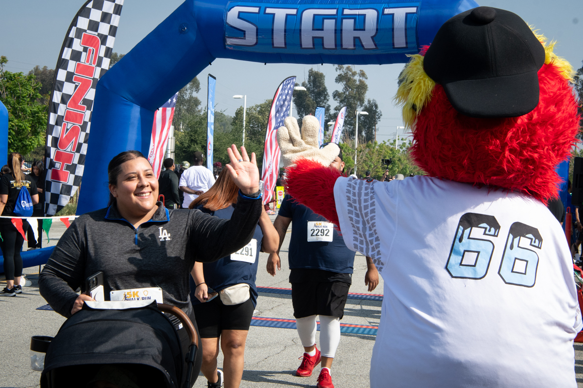 The Inland Empire 66ers Mascot Bernie celebrates with a walker coming across the finish line at the May 2, 2026, Arrowhead Regional Medical Center (ARMC) 5K Walk/Run in Colton. 